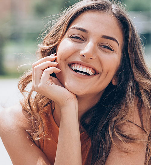 Featured Procedures: Fillers for acne scars (smiling female model)