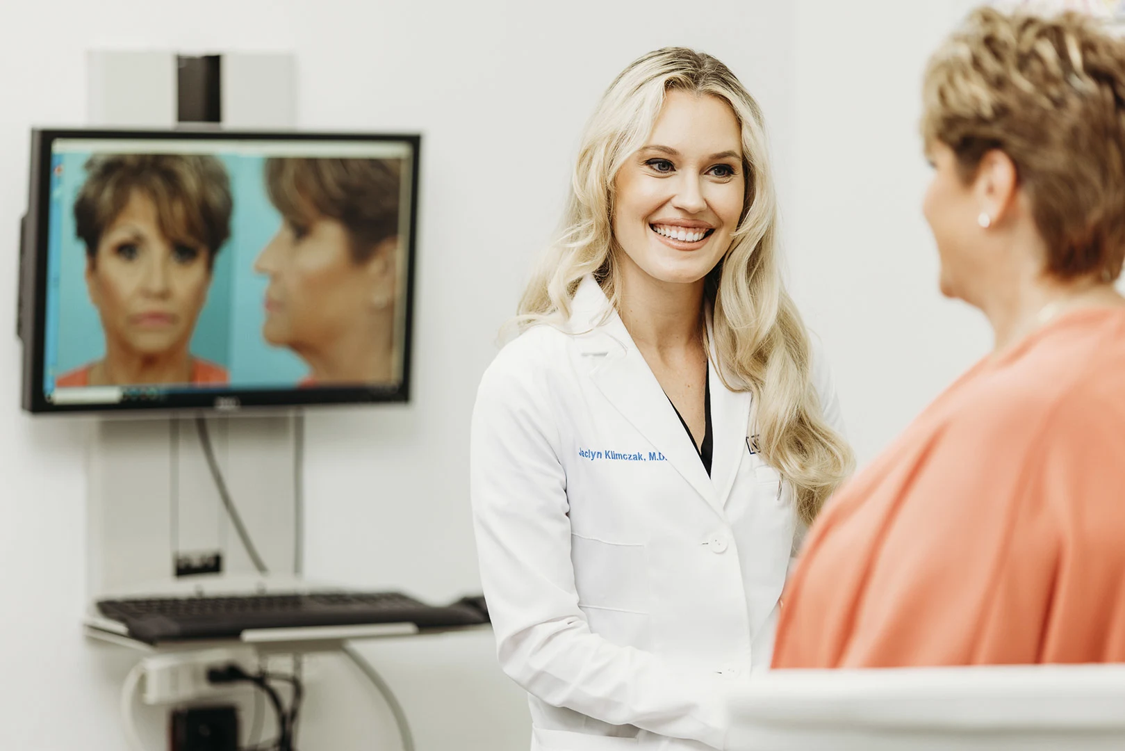 Brow lift consultation: Surgeon reviewing before and after photos with female patient
